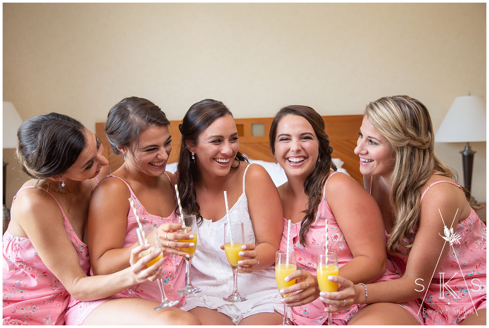  Bridesmaids wearing pink pajamas and drinking mimosas 