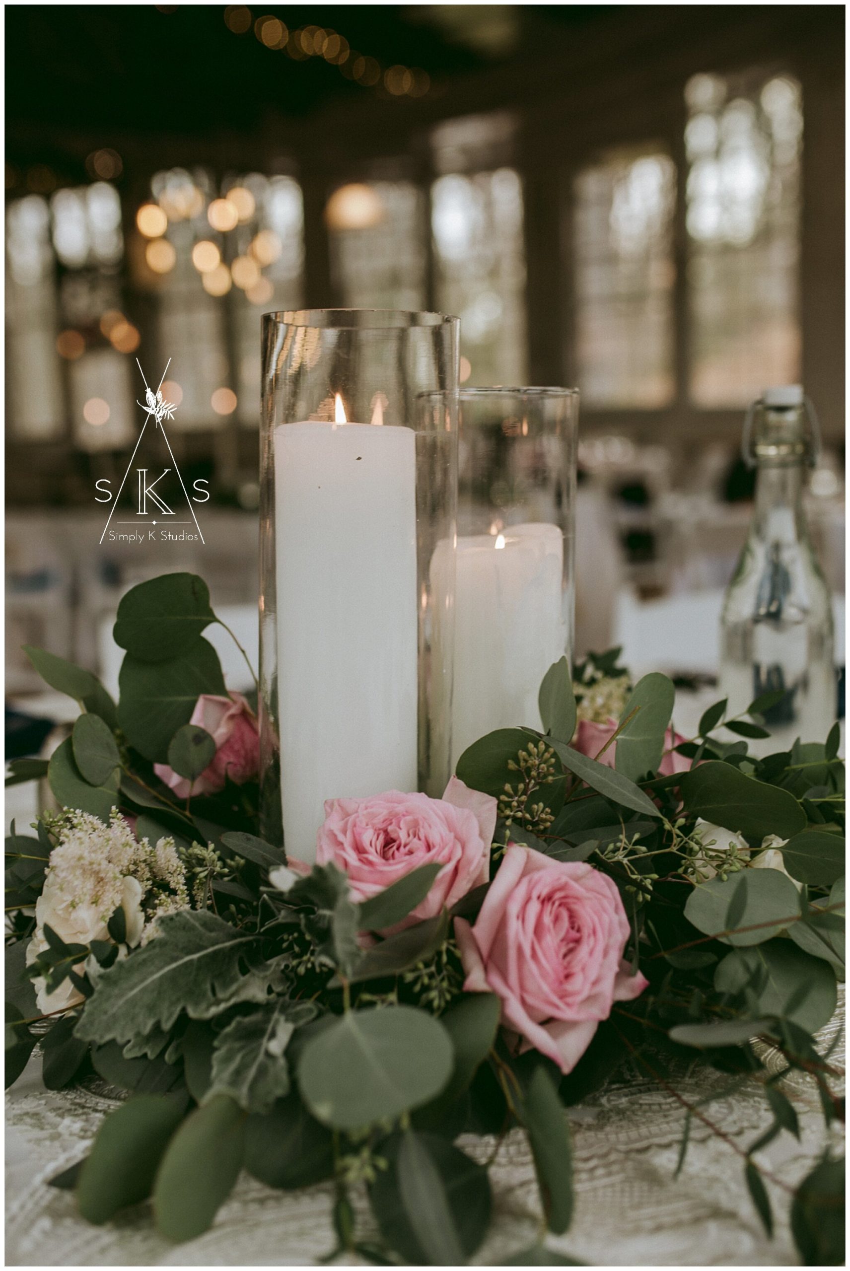  white pillar candles with a pink rose at the base 