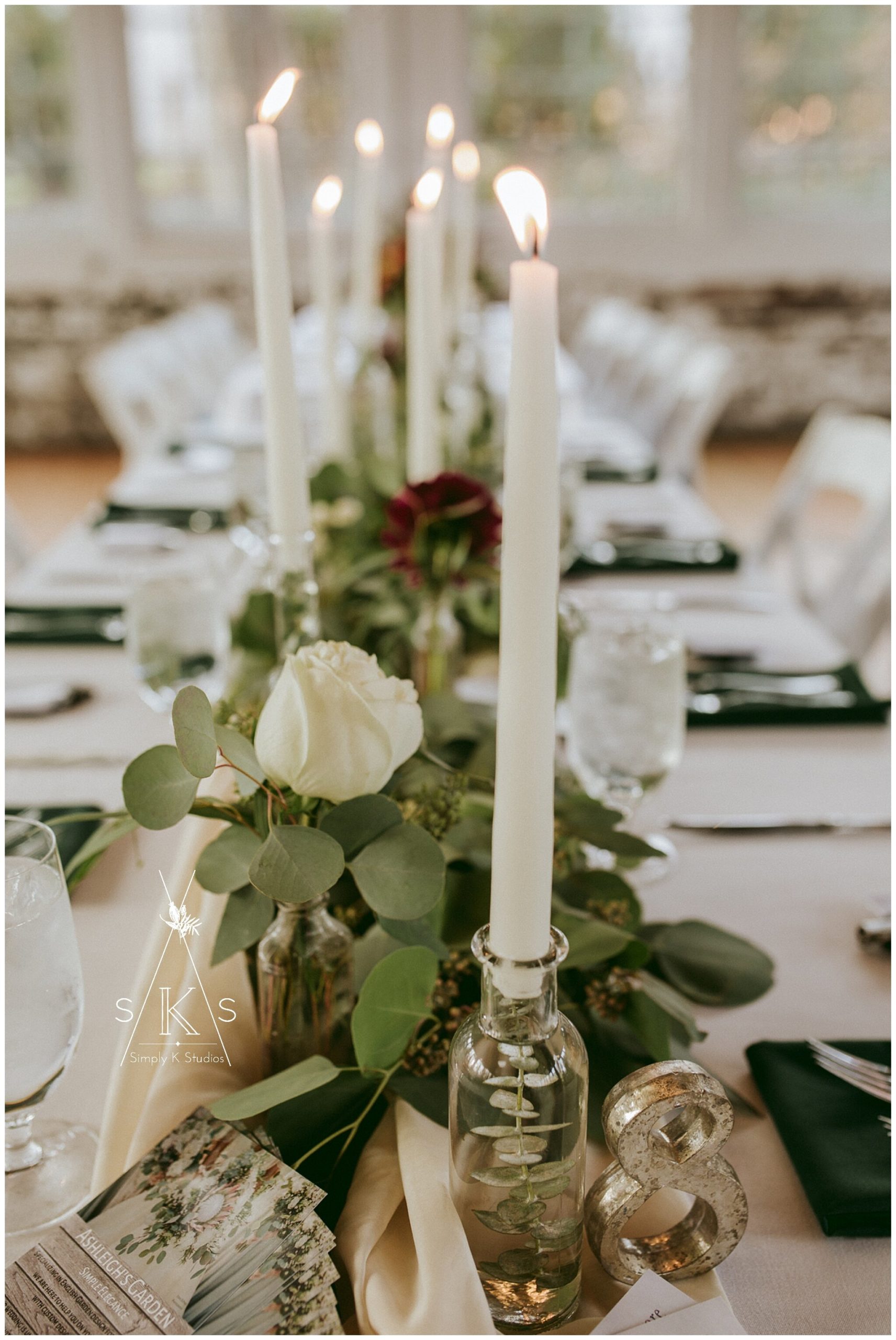  white candlesticks on a table with flowers 