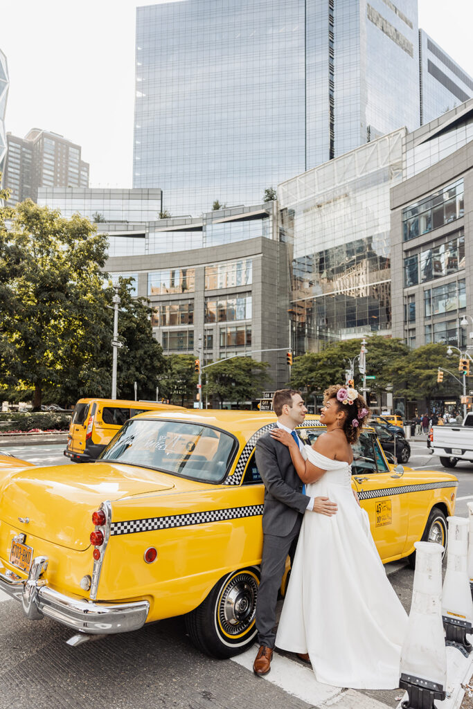 bride and groom posing by a vintage cab in NYC