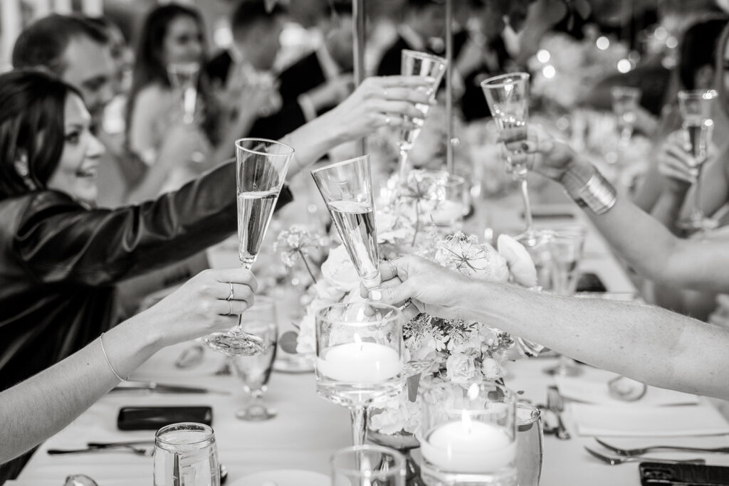 wedding guests toasting and cheering across the table