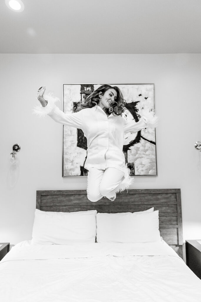 bride jumping for joy on the bed