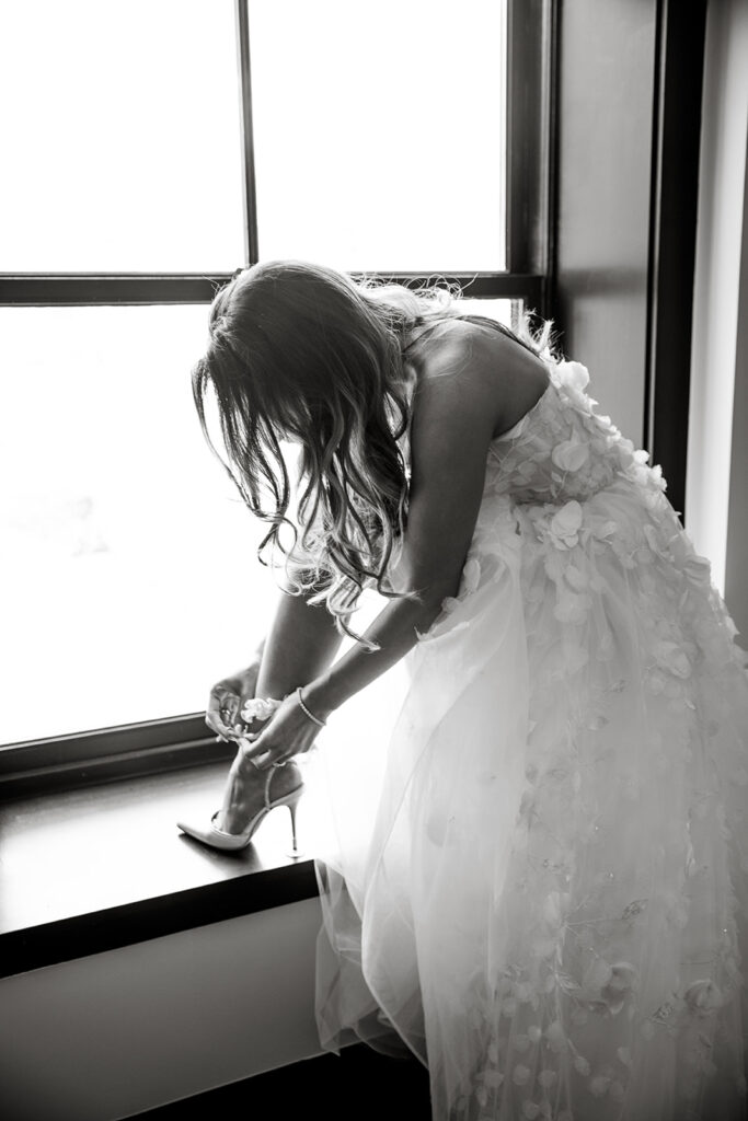 bride buttoning up her shoe