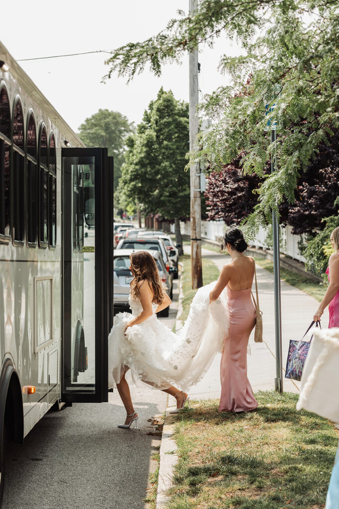 bridesmaid carrying bride's dress 