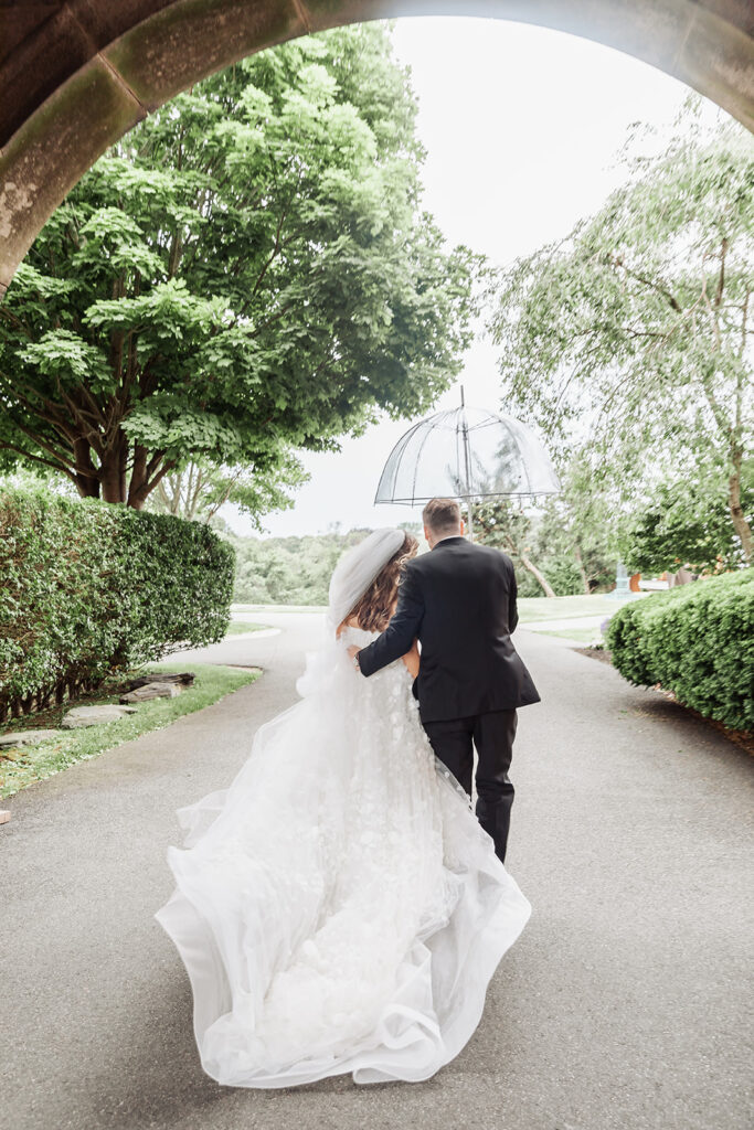 bride and groom under a clear umbrella