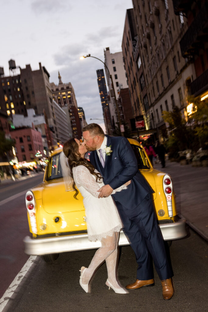 bride and groom kissing in front of an iconic nyc yellow cab